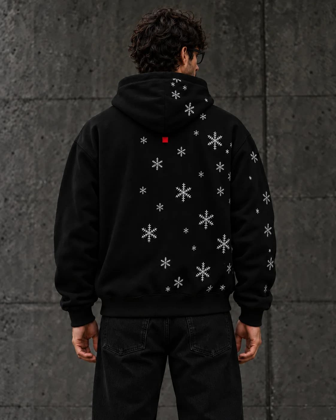 The hoodie from the back, snowflakes embroidered across one side and the hood.