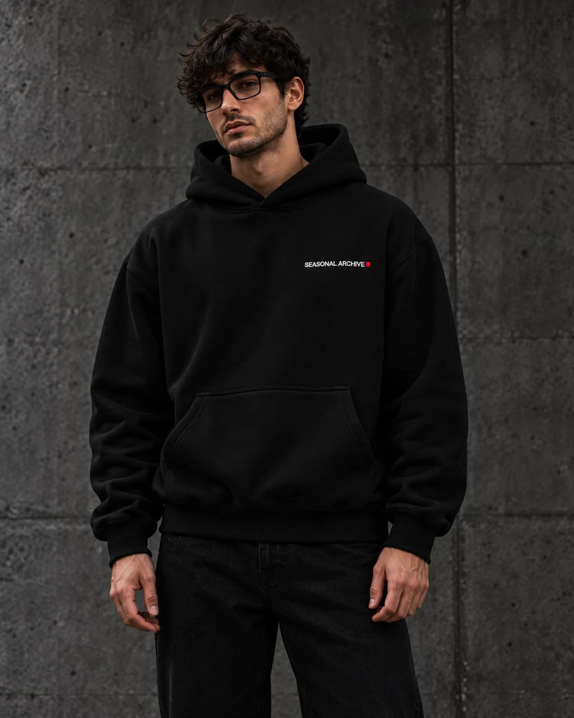 A model in the oversized hoodie, the wordmark embroidered on the left chest.